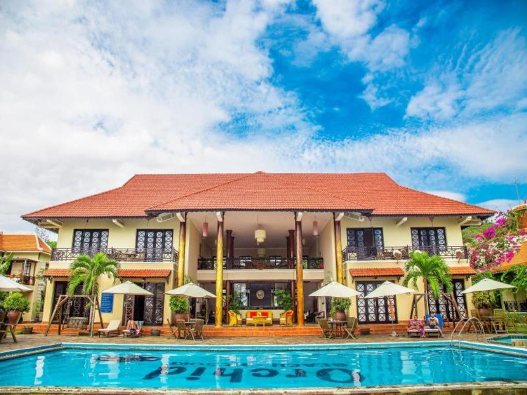 um hotel com piscina em frente a um edifício em Orchid Boutique Beach Resort em Phan Thiet