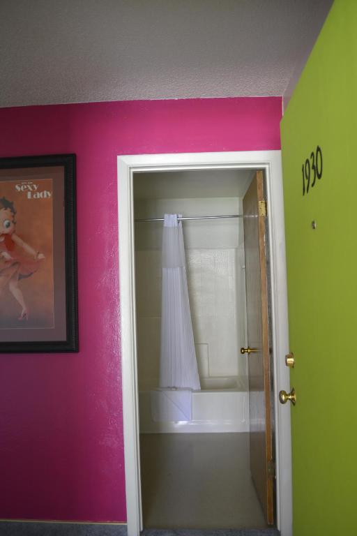 a bathroom with pink and green walls and a mirror at Retro Inn at Mesa Verde in Cortez
