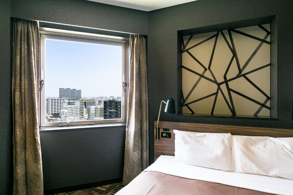 Postel nebo postele na pokoji v ubytování Sotetsu Fresa Inn Kawasaki-Higashiguchi