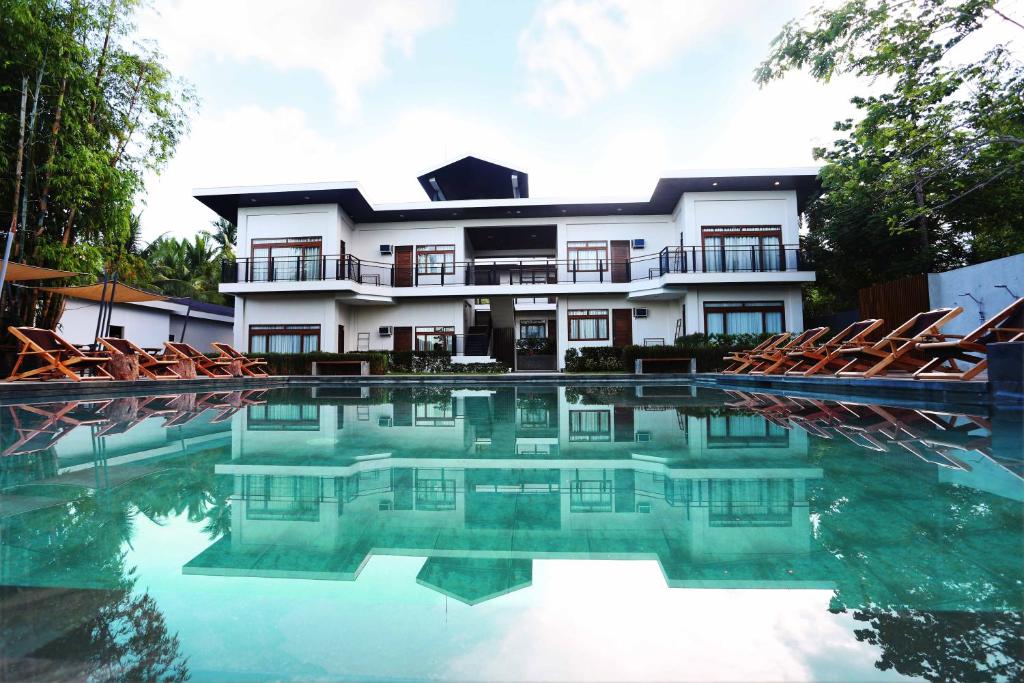 a house with a swimming pool in front of it at The Funny Lion - Coron in Coron