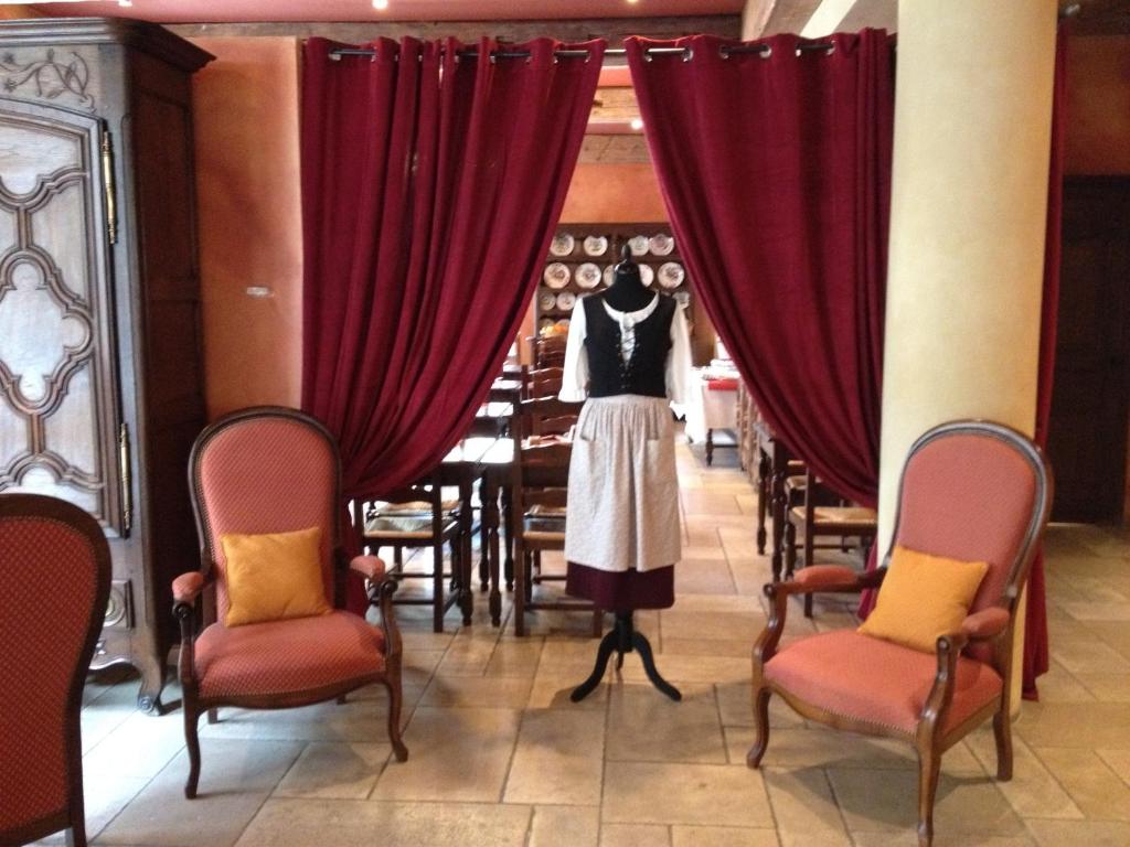 a mannequin in a room with red curtains and chairs at Hôtel Du Théâtre Centre Historique Parking Gratuit in Metz