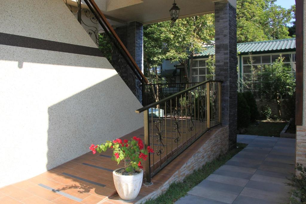 a porch with a potted plant and a railing at Champs Yazuh B&amp;B in Jiji