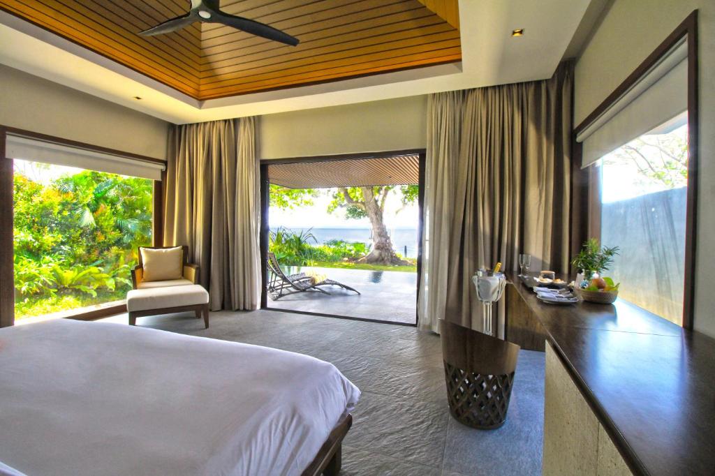 a bedroom with a bed and a view of the ocean at Amorita Resort in Panglao