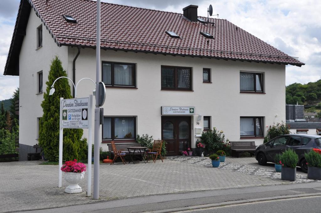 a white house with a sign in front of it at Pension Dabrunz in Heimbach