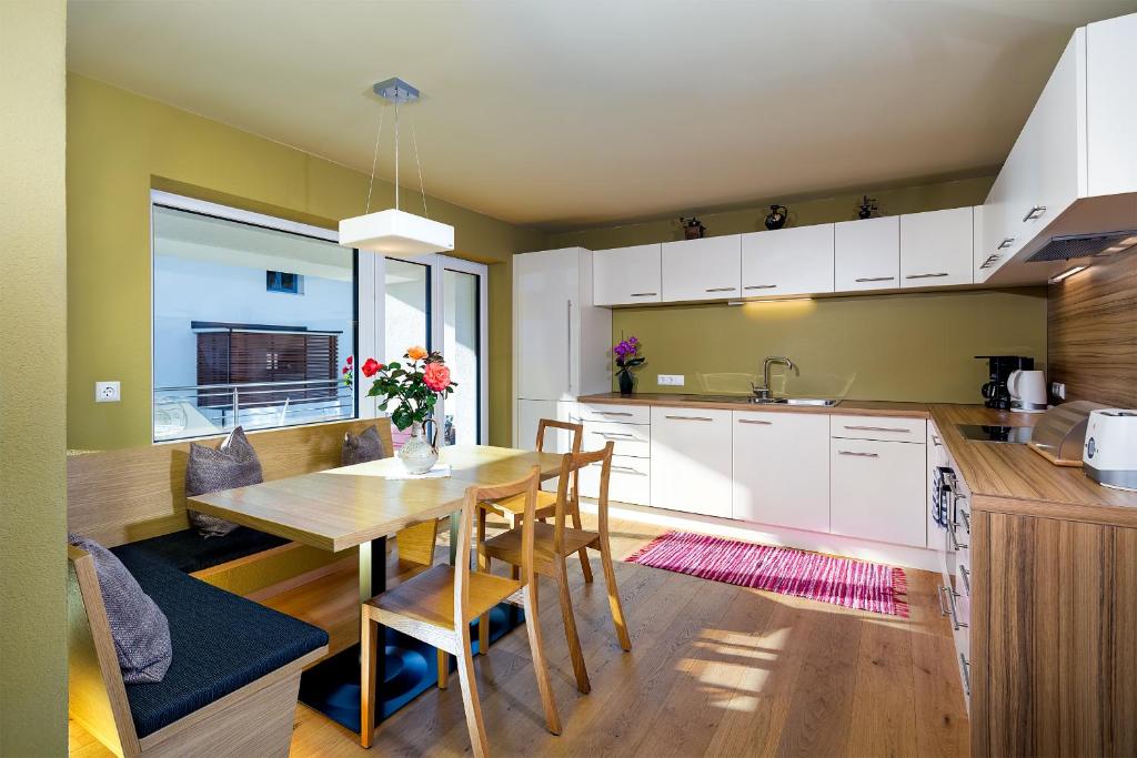 eine Küche und ein Esszimmer mit einem Holztisch in der Unterkunft Ferienraum Pfunds in Pfunds