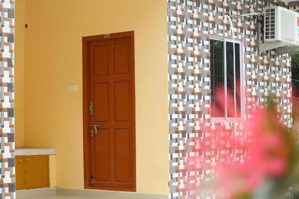 a room with a door and a wall with tiles at Arun Cottages in Mahabalipuram