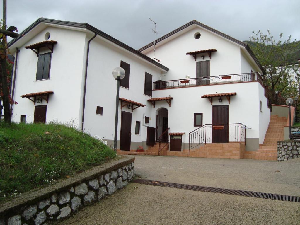 a large white house with a stone wall at Agriturismo Costiera Amalfitana in Tramonti