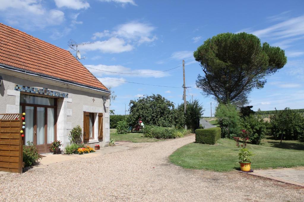 a house with a gravel driveway next to a building at Gîte de La Huaudière in Mosnes