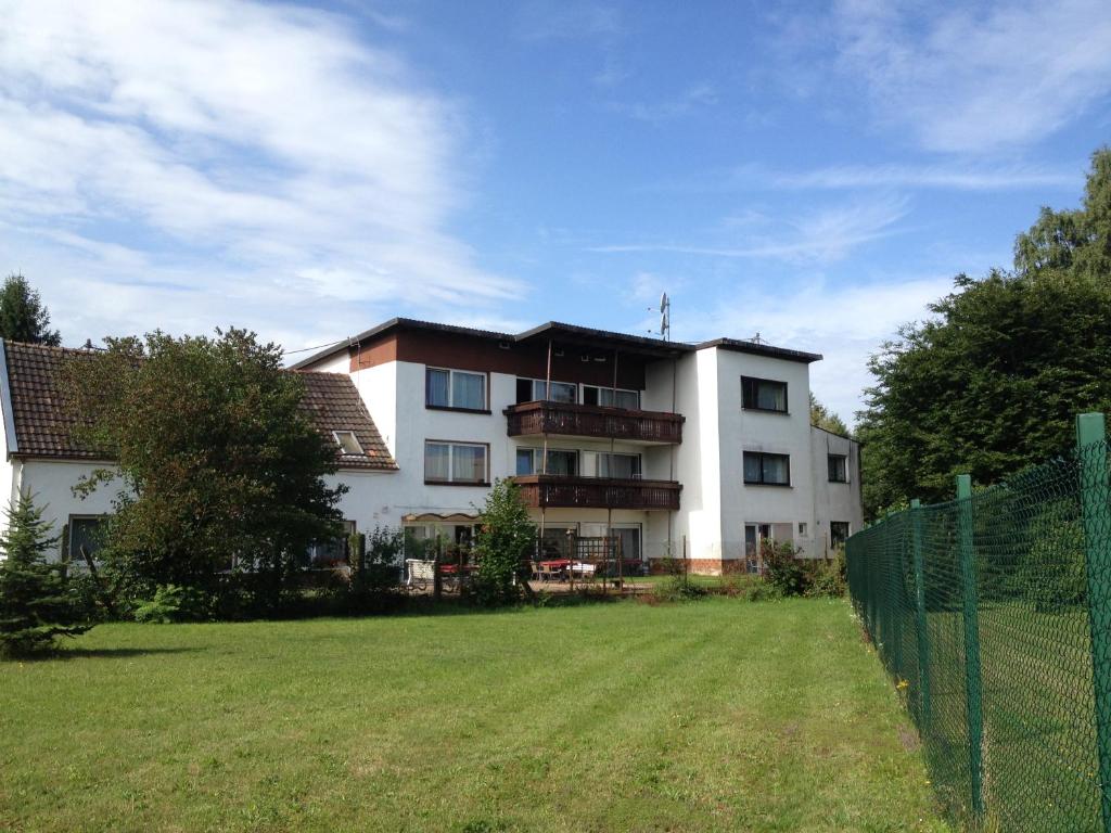 a large white building with a yard in front of it at Hotel Saarland Lebach in Lebach