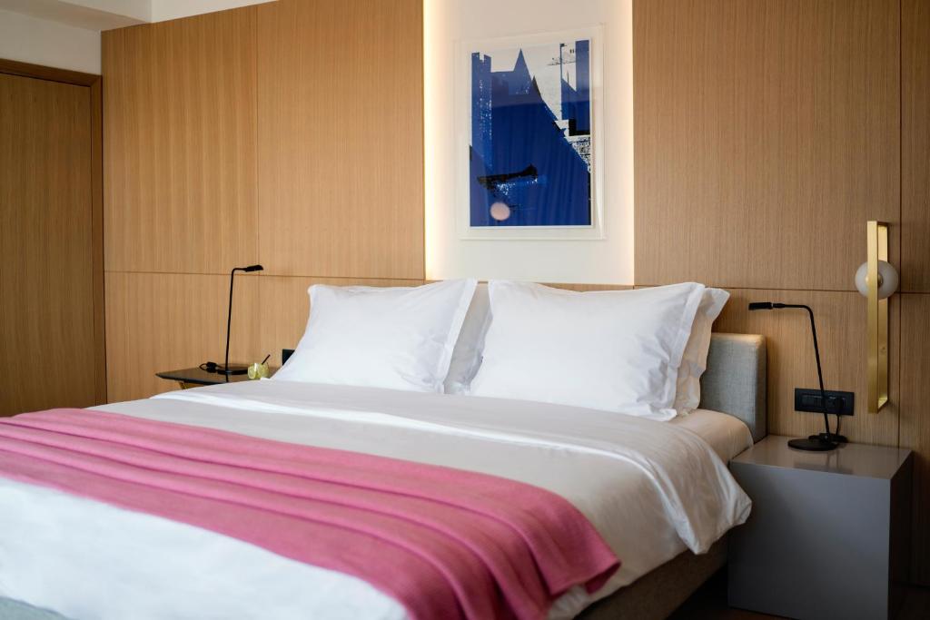 a large bed with white sheets and a pink blanket at Hotel Excelsior in Dubrovnik