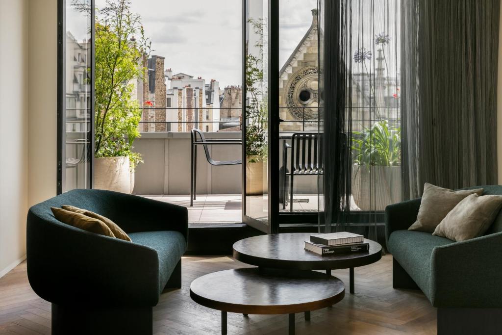 un salon avec deux chaises et une table basse dans l'établissement Hôtel National Des Arts et Métiers, à Paris
