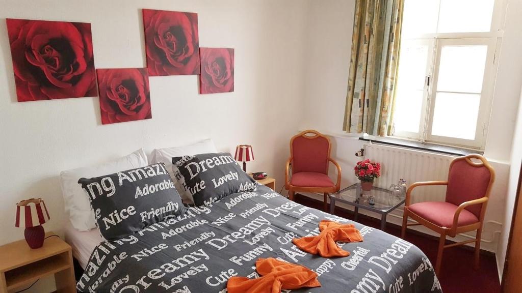 um quarto com uma cama com roupões laranja em Hotel de Kroon em Epen