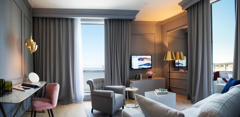 a living room with a couch and a tv at Hotel Excelsior in Dubrovnik