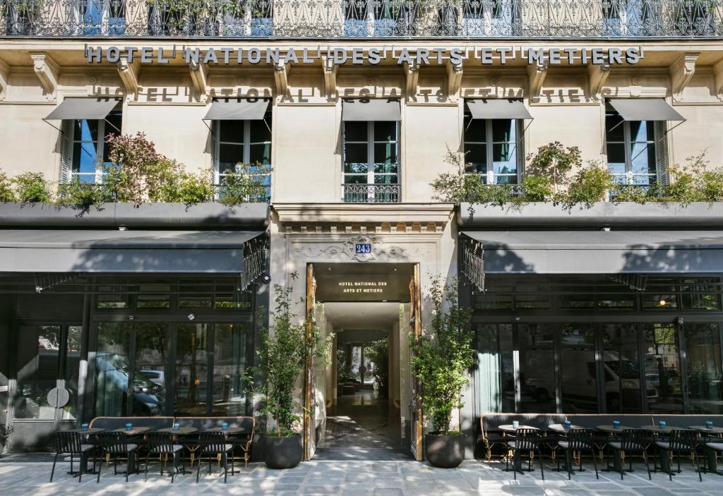 a building with tables and chairs in front of it at Hôtel National Des Arts et Métiers in Paris