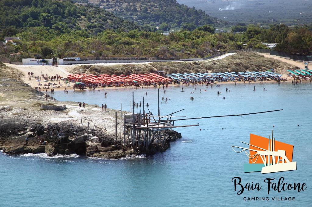 - une plage avec des parasols et des personnes dans l'eau dans l'établissement Camping Village Baia Falcone, à Vieste