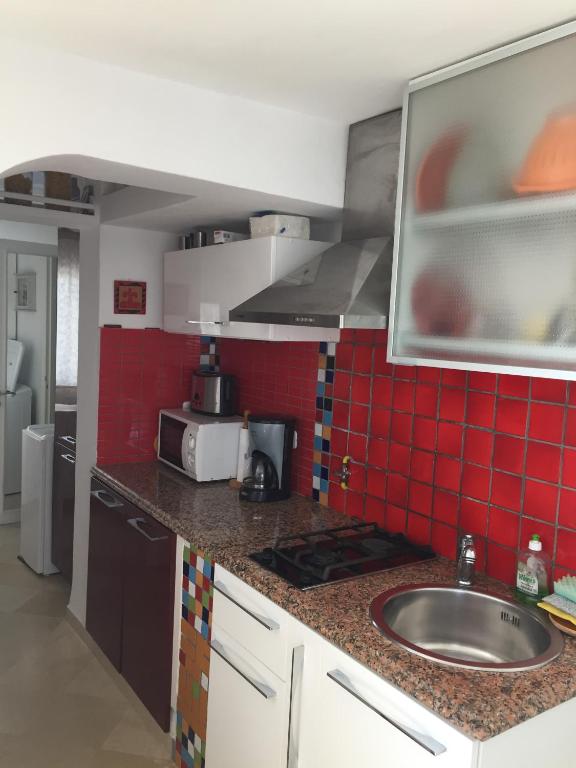 a kitchen with a sink and red tiles on the wall at Appartement - Vue sur Mer- Hammamet in Hammamet