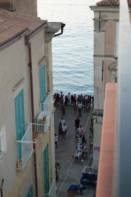 a group of people walking down a street near the water at B&B The Tower in Tropea