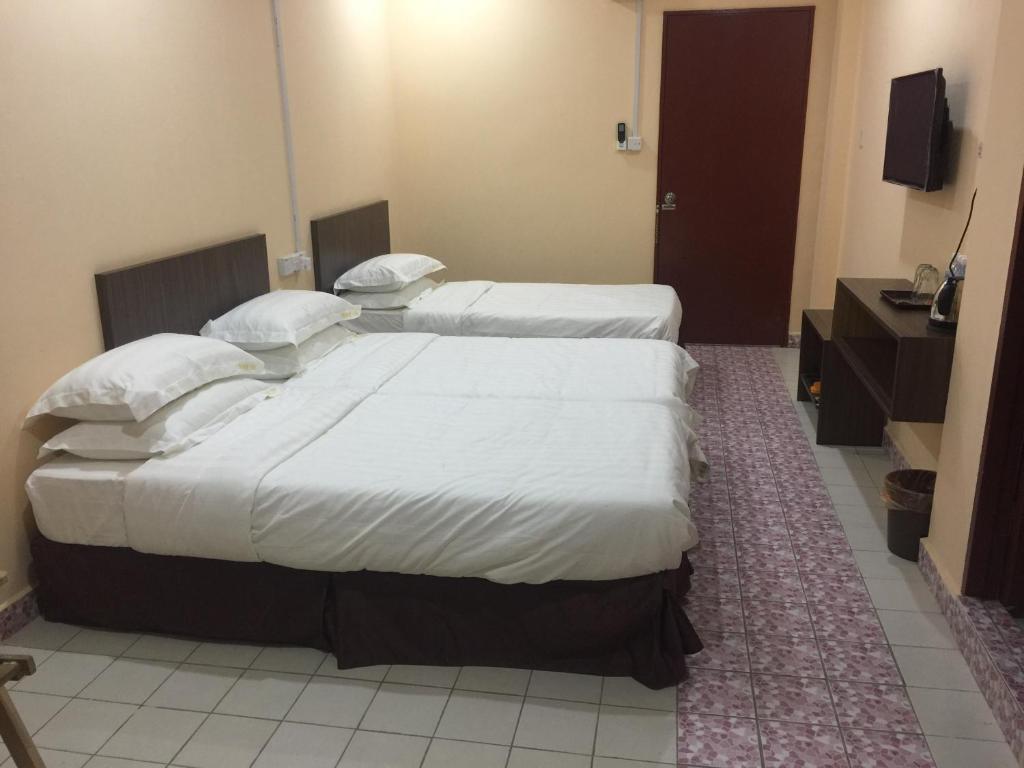 Postel nebo postele na pokoji v ubytování Indah Inn