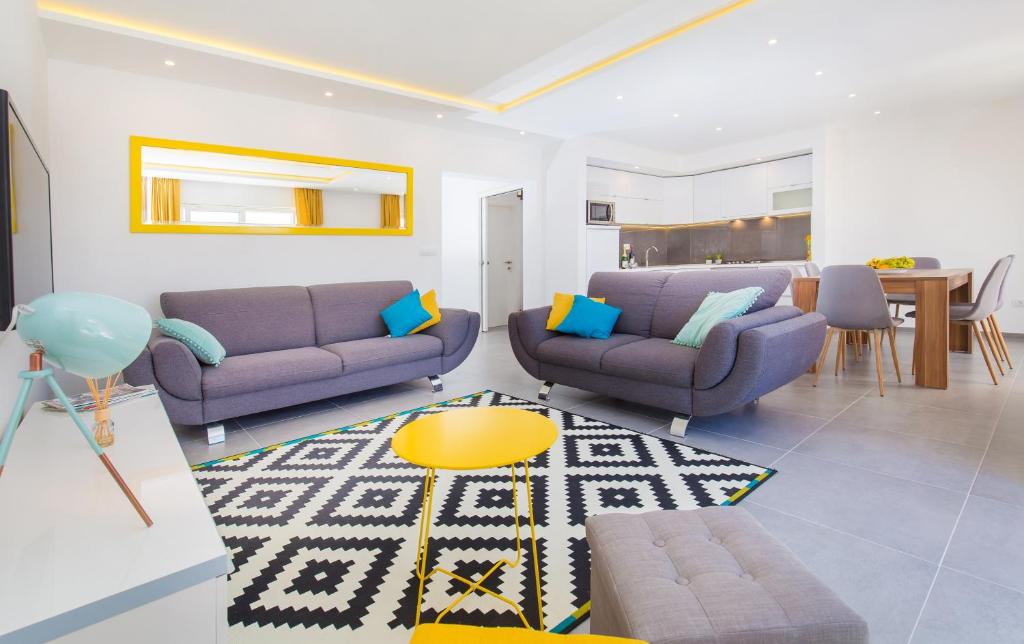 a living room with two purple couches and a table at Apartments Marivo in Mlini