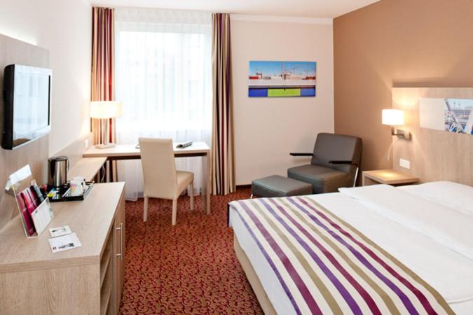 a hotel room with a bed and a desk at Mercure Hotel Hamburg am Volkspark in Hamburg