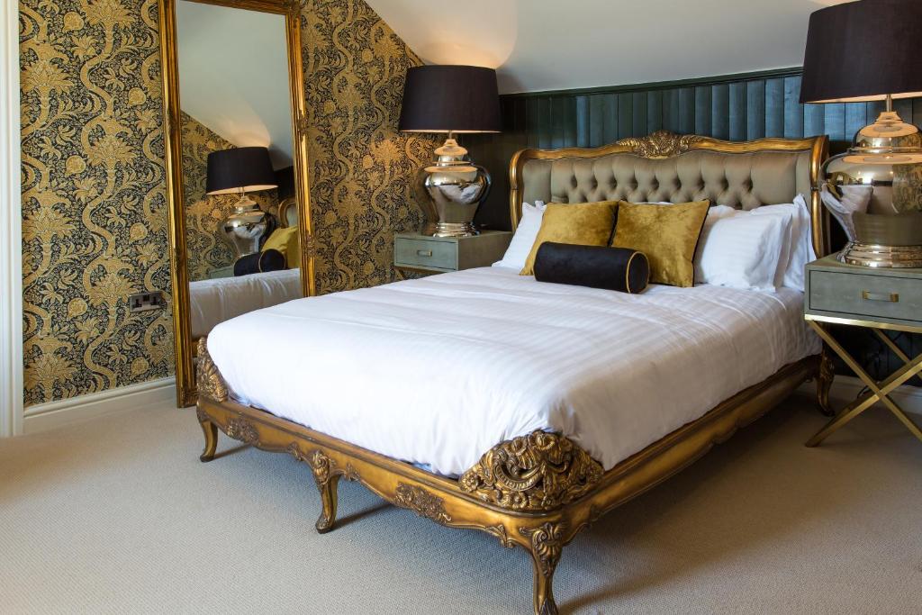
a bedroom with a large bed and a large mirror at The Dirty Bottles Inn in Alnwick
