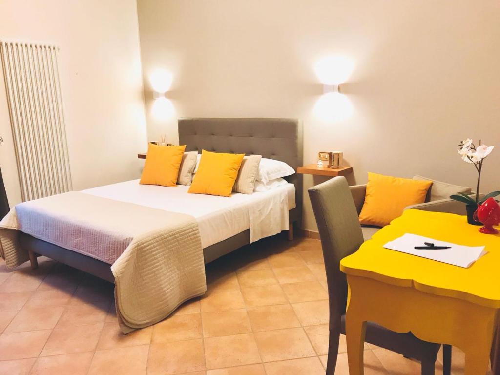 a bedroom with a bed with yellow pillows and a table at A DUE PASSI temporary apartment in Trani