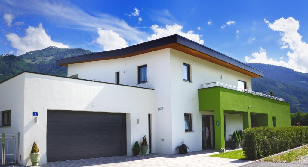 Biały i zielony dom z garażem w obiekcie Greenhome Appartement w mieście Niedernsill