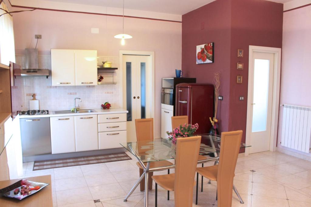 eine Küche und ein Esszimmer mit einem Glastisch in der Unterkunft Eleatica Holiday Apartment in Ascea