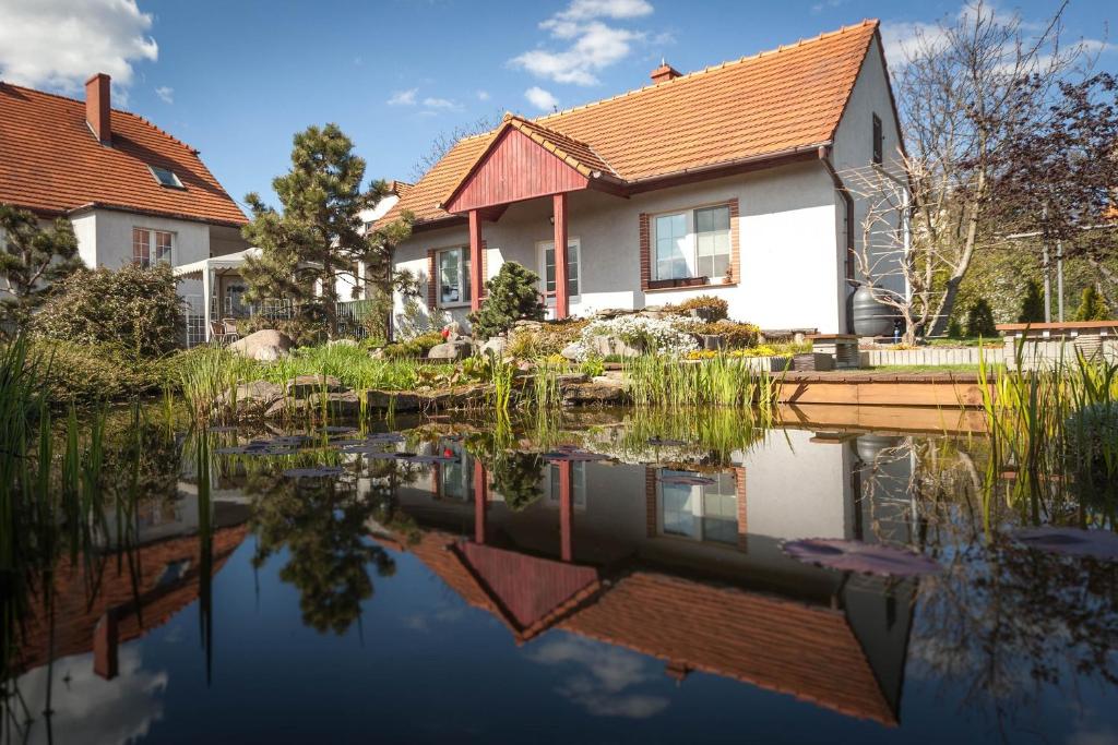 a house and its reflection in the water at Domek w ogrodzie in Chełmno