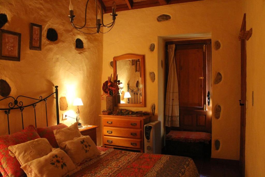 AguloにあるCasa Rural Las Rosasのベッドルーム1室(ベッド1台、ドレッサー、鏡付)