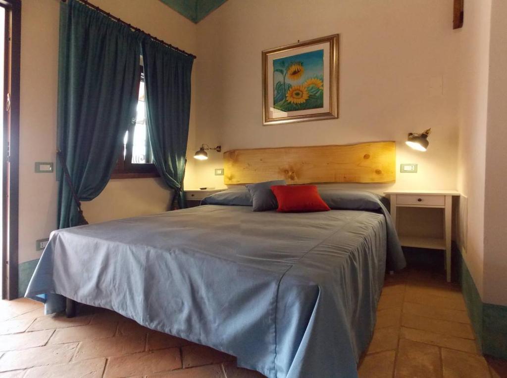 um quarto com uma cama com uma almofada vermelha em Agriturismo Cento Ducati em Palombara Sabina