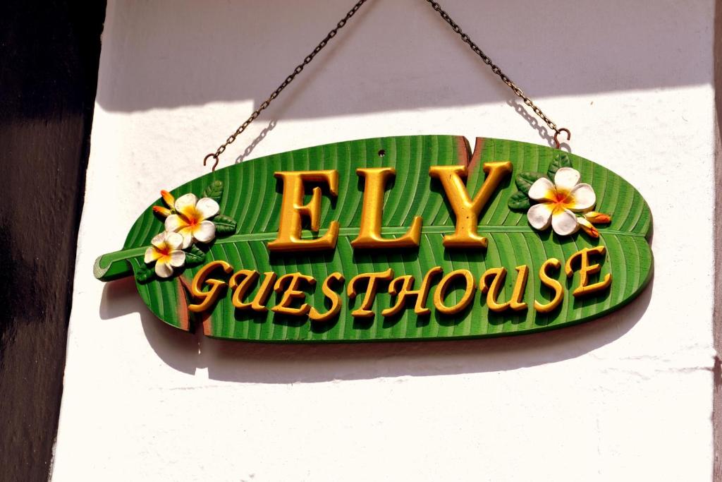 un cartel colgando de una pared con flores. en Ely Guest House en Ely