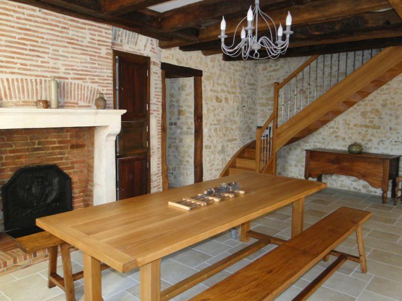 - une table en bois dans une chambre avec cheminée dans l'établissement Gite La Grange, à Morogues