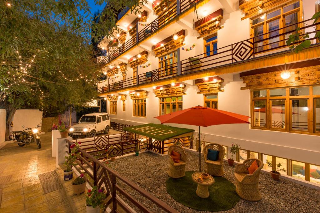 an outdoor patio of a hotel with a table and chairs at Zostel Leh in Leh