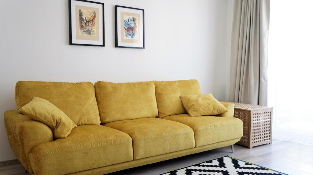 ブラショヴにあるTUDOR's placeの黄色いソファーが置かれたリビングルーム