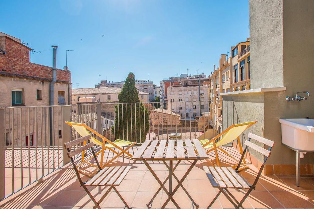 a patio with chairs and a table on a balcony at Flateli - Plaça Catalunya 42 in Girona