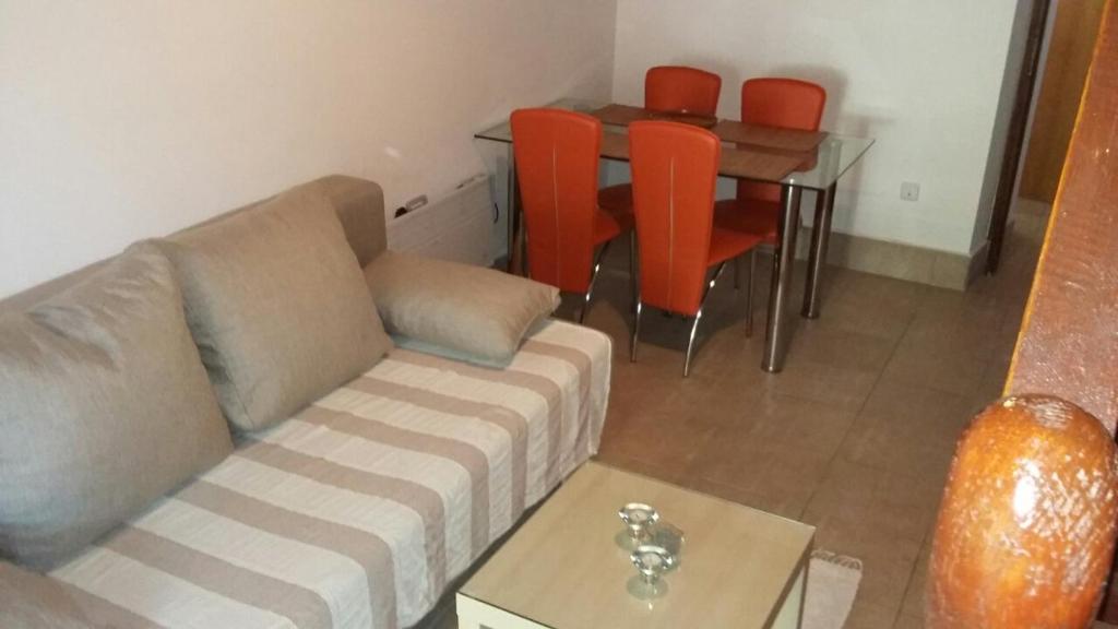 a living room with a couch and a table with orange chairs at Casa Ida in Šišan