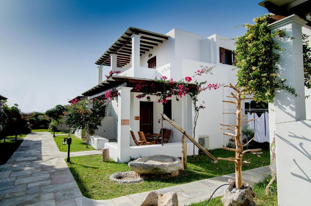 uma casa branca com um jardim em frente em Anemonisia Deluxe Apartments em Skiros