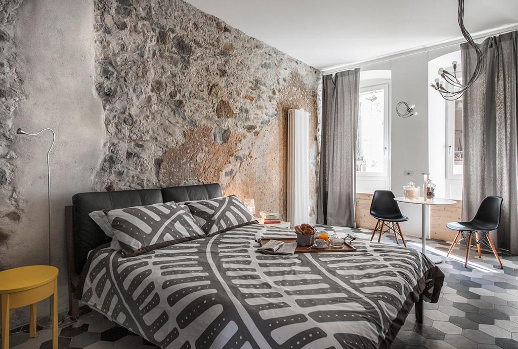 1 dormitorio con cama y pared de ladrillo en La Casa Della Zia, en Sarnico