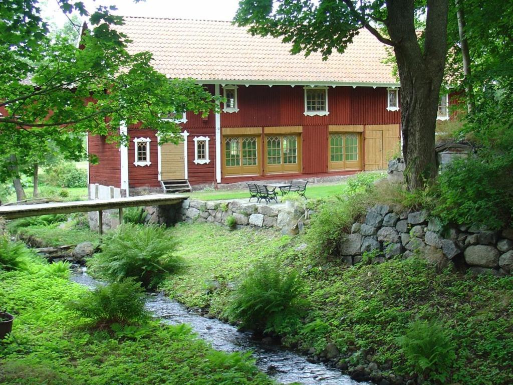 a red house with a stream in front of it at Björka Storgård B&B in Motala