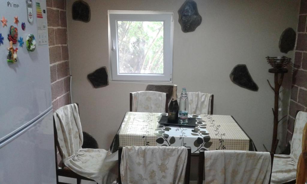 ein Esszimmer mit einem Tisch, Stühlen und einem Fenster in der Unterkunft Guest House Nima in Bordschomi
