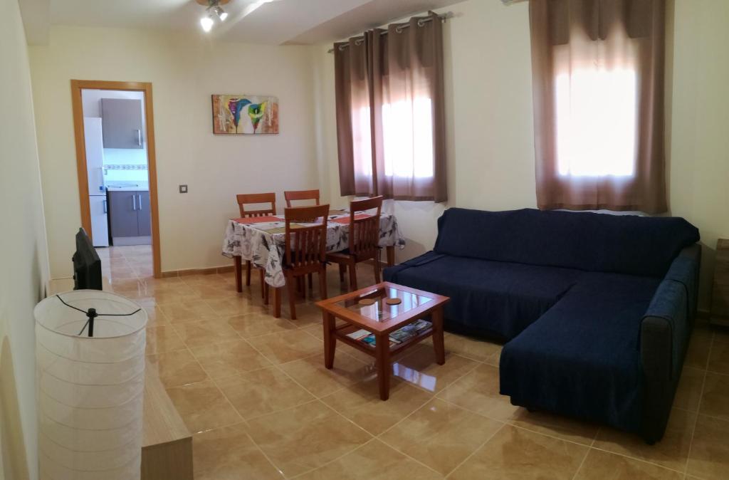 a living room with a blue couch and a table at Apartamento fuerte 2 in Puerto del Rosario