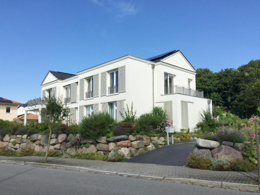 ein weißes Haus mit Gartenanlagen davor in der Unterkunft Ferienwohnung *Richi* in Sassnitz
