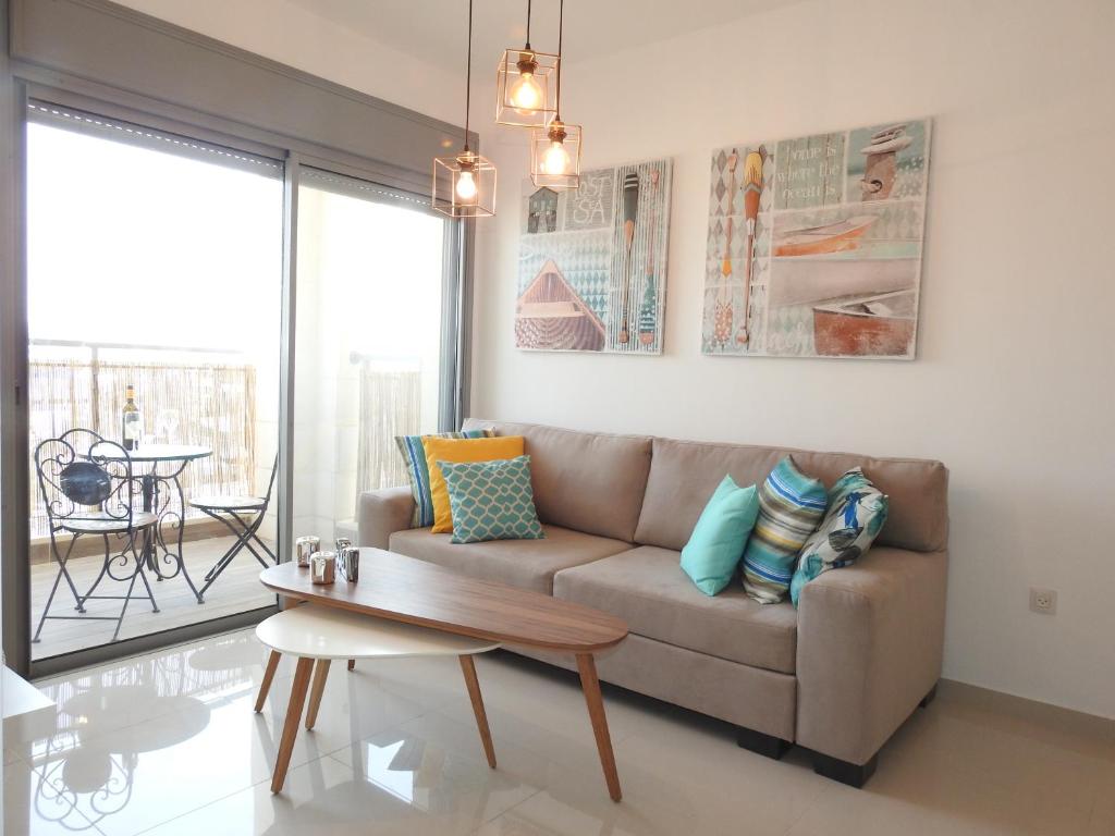 een woonkamer met een bank en een tafel bij ERA home boutique in Eilat