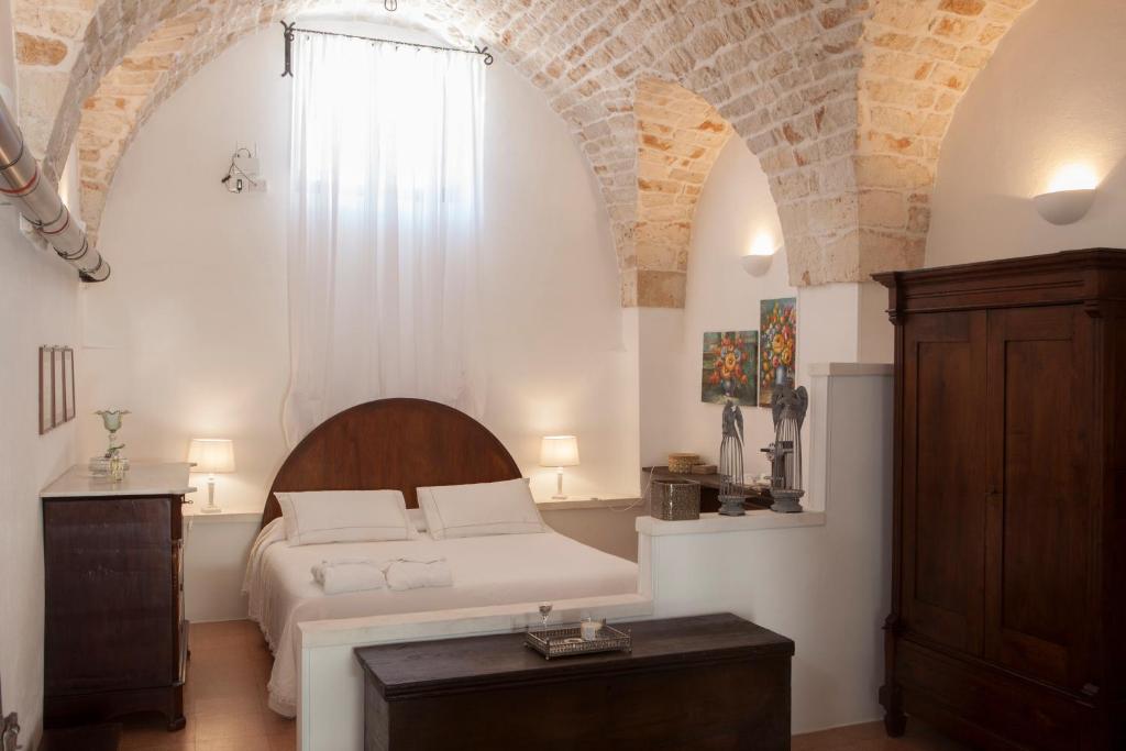 a bedroom with a white bed and a window at Masseria Il Frantoio in Ostuni