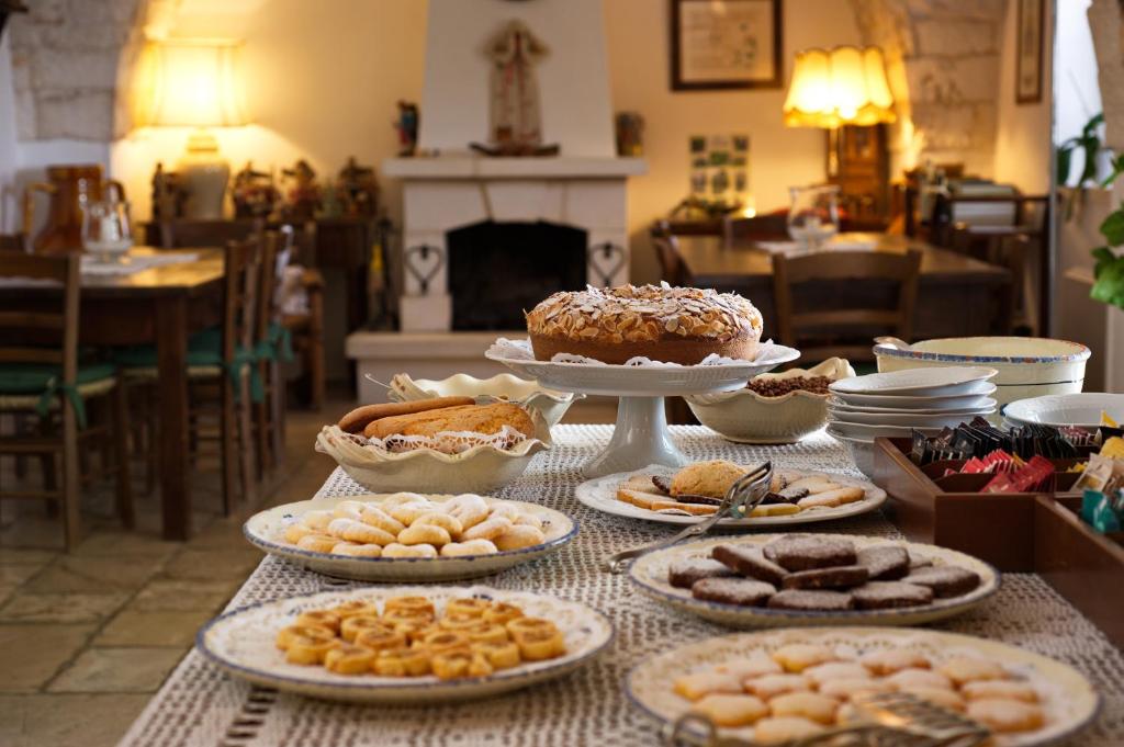 a table topped with plates of pastries and desserts at Masseria Il Frantoio in Ostuni