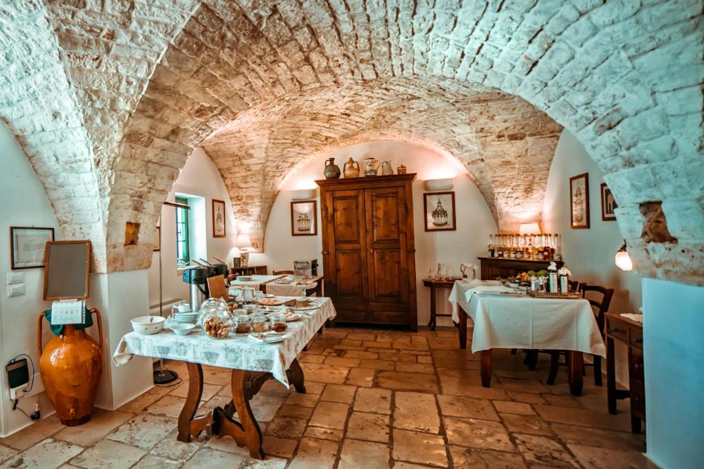 a restaurant with two tables in a room with stone walls at Masseria Il Frantoio in Ostuni