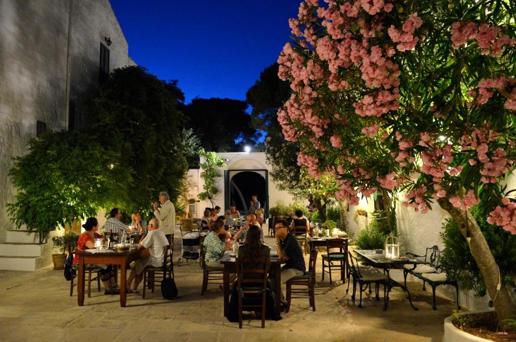 a group of people sitting at tables at a restaurant at Masseria Il Frantoio in Ostuni
