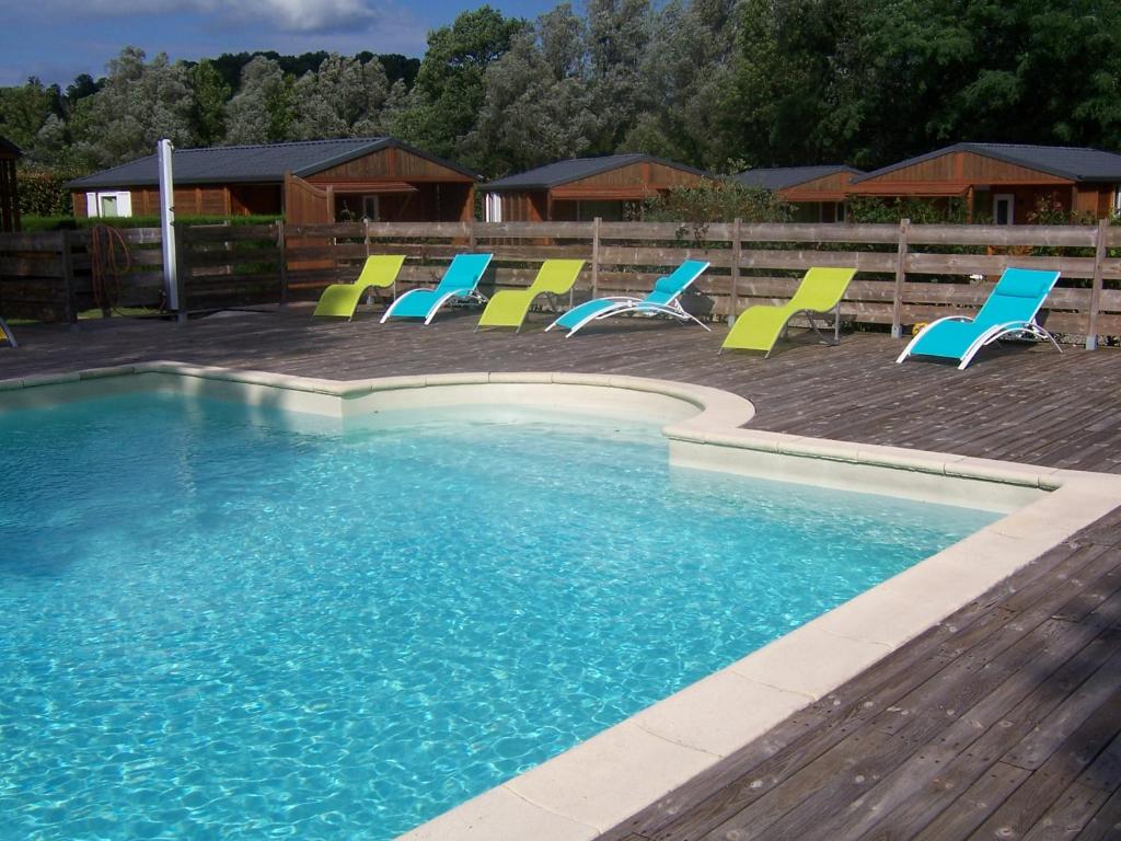 un grupo de sillas sentadas alrededor de una piscina en La Tour du Loup, en La Bastide-de-Sérou