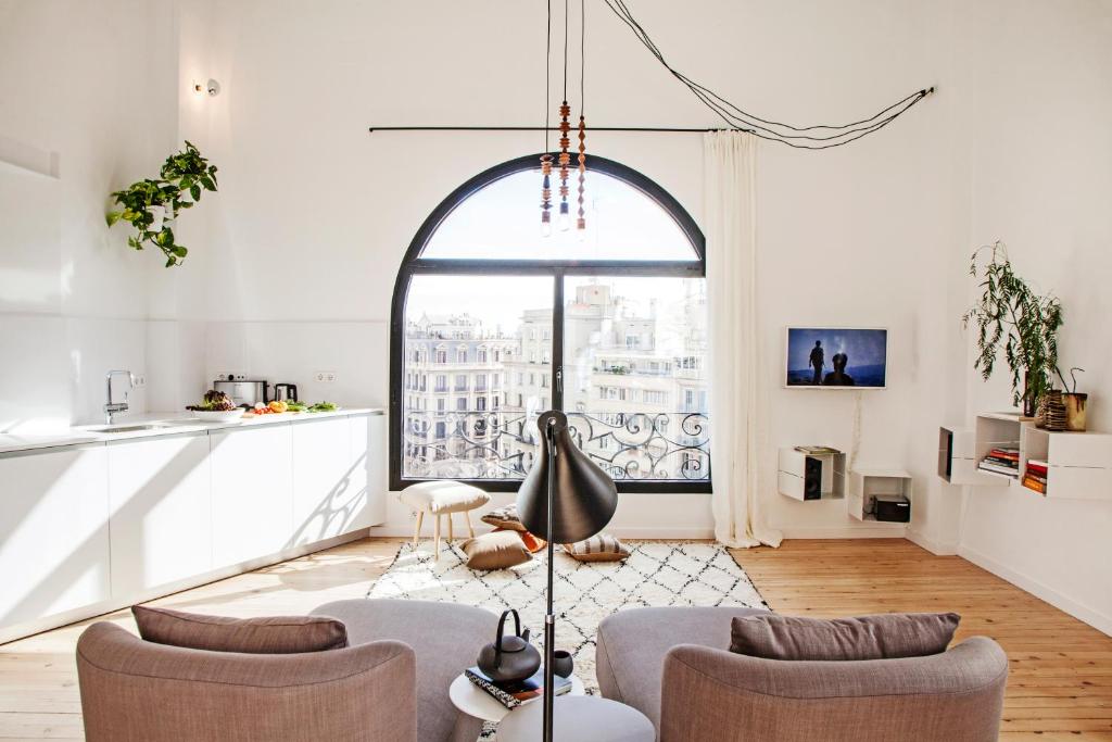 a living room with two chairs and a large window at DestinationBCN Marimon Apartment in Barcelona